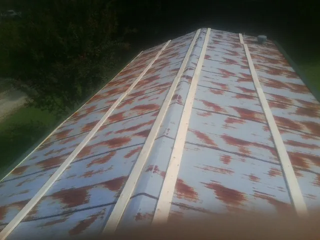 Rusted metal roof panels with new wood purlins before replacement — Storm Damage Roof Repair in Binger by Roofing Brothers