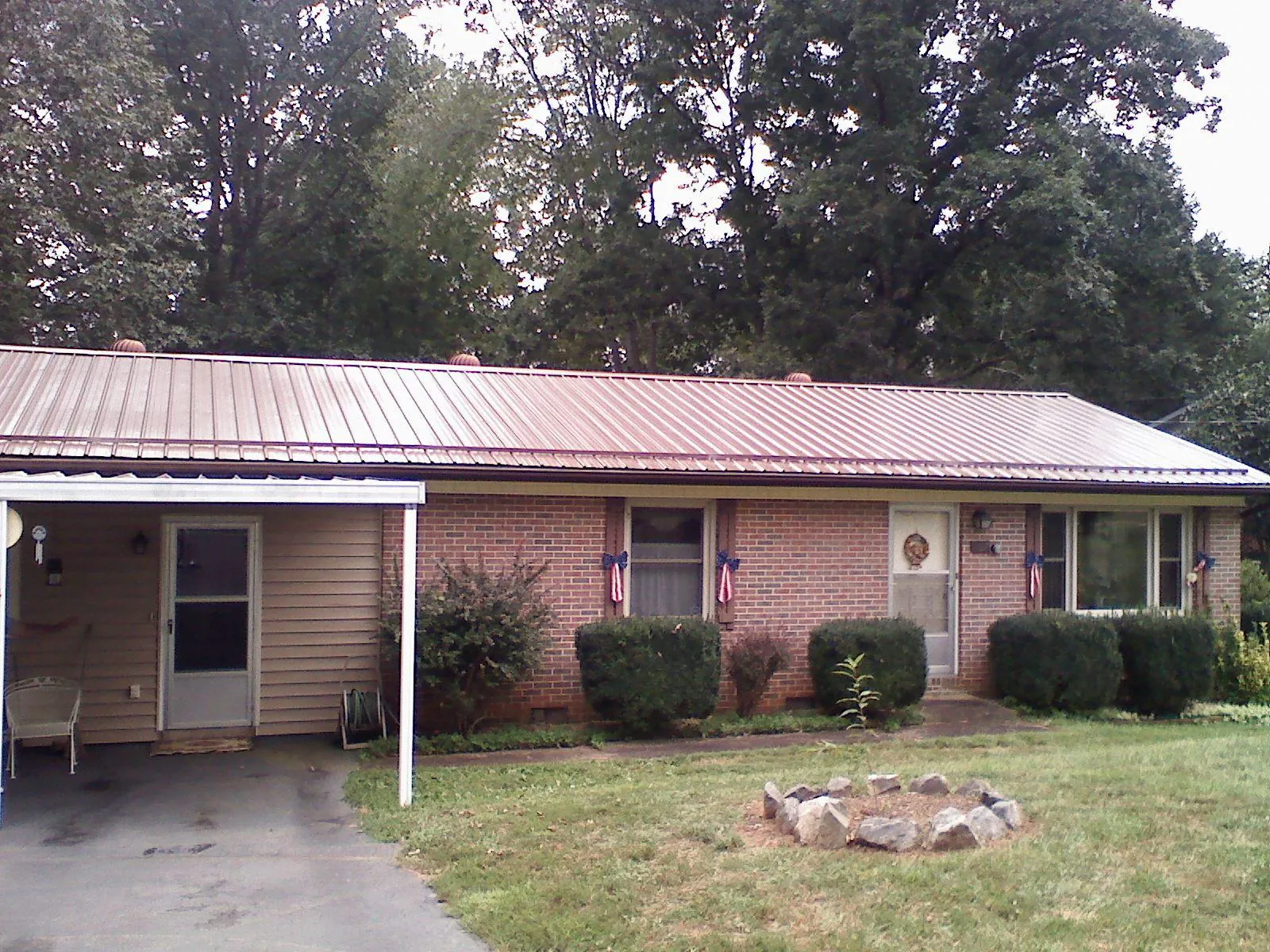 Bronze metal roof and carport on a brick ranch home — Roof Repair work by our crew in Binger