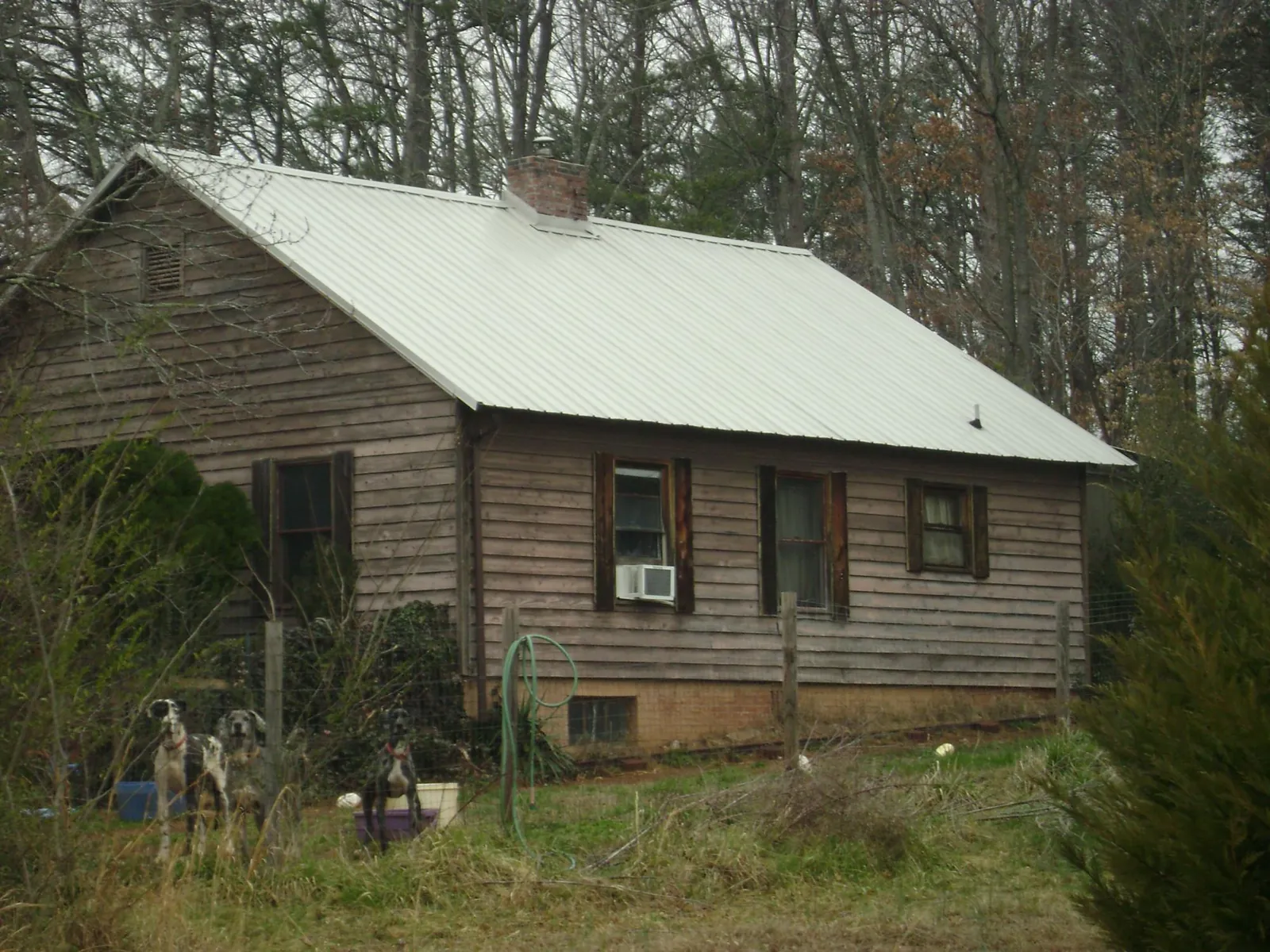 White metal roof on an old wood sided farmhouse, from a Metal Roof Installation job in Binger